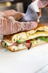 addetto alla preparazione panini che prepara un panino